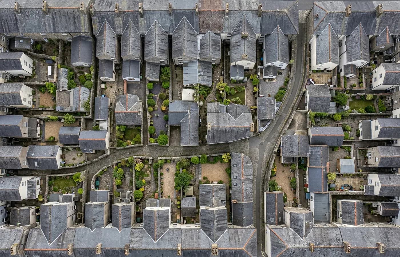 A straight down aerial view of a dense town centre roofscape with yards, extensions and boundary walls clearly separated